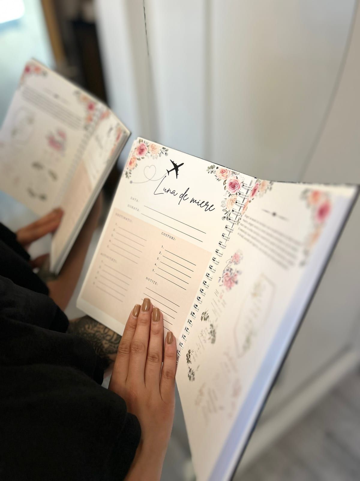 Agenda deschisă la pagina „Luna de miere”, cu mâna pe filă